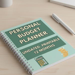 Può includere: Un pianificatore di budget personale rilegato a spirale con una copertina verde menta. La copertina presenta il testo "PERSONAL BUDGET PLANNER" e "UNDATED, PRINTABLE 12 MONTHS". È presente anche una grafica di calcolatrice e monete d'oro.