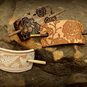 Puede incluir: Tres pinzas para el pelo de madera con dise&ntilde;os florales. Las pinces est&aacute;n hechas de madera y tienen un acabado natural. Los dise&ntilde;os est&aacute;n tallados en la madera y son muy detallados. Las pinces son perfectas para sujetar el pelo en su lugar y a&ntilde;adir un toque de estilo a cualquier atuendo.