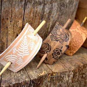 Puede incluir: Tres palos de pelo de madera con dise&ntilde;os decorativos. Los palos est&aacute;n hechos de madera y tienen un acabado natural. Los dise&ntilde;os est&aacute;n tallados en la madera y son intrincados y detallados. Los palos son una excelente manera de agregar un toque de estilo a cualquier peinado.