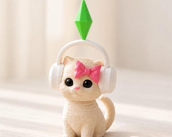 May include: A small beige cat figurine with large black eyes and a pink bow on its head. The cat wears white over-ear headphones topped with a bright green diamond-shaped plumbob icon. The figure has a textured surface and a curled tail.
