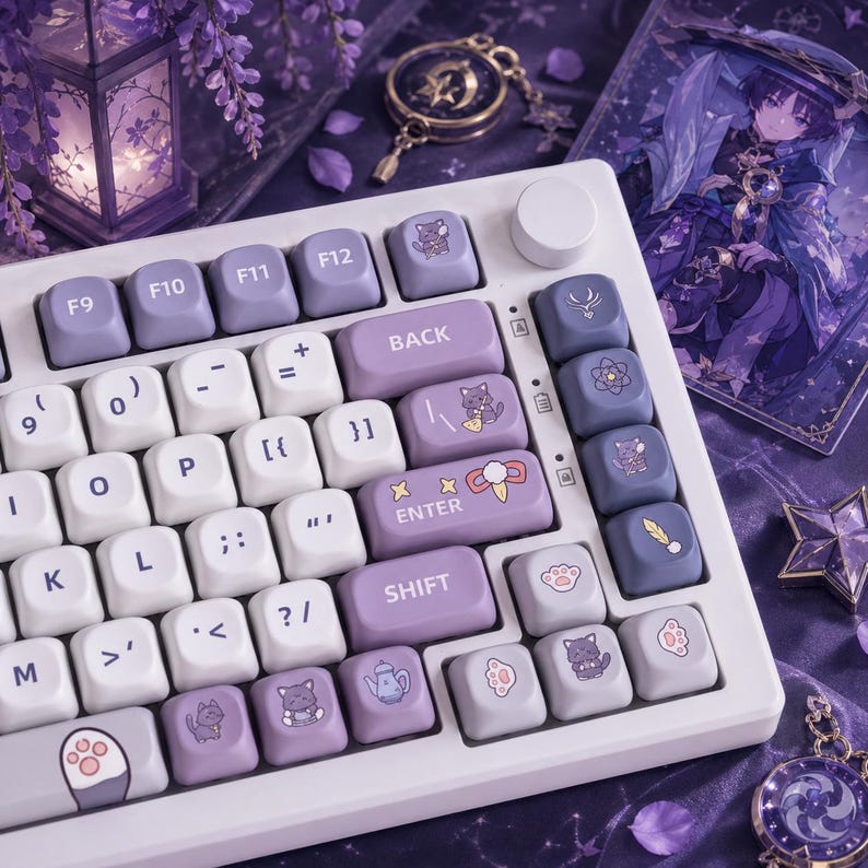 May include: A white mechanical keyboard with custom keycaps in shades of purple and white. The keycaps feature cat and paw print designs. The keyboard has a round volume control and a variety of function keys.