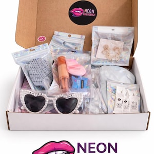 May include: A cardboard box containing various items, including heart-shaped sunglasses with "BRIDE TO BE" on them, a hairbrush, and small packages. The box has a "NEON EMERGENCY" logo. Items are in clear plastic bags.