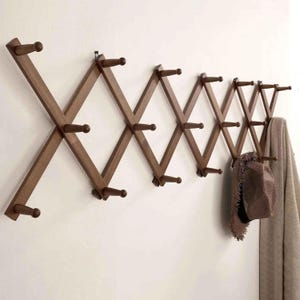 May include: A white ceramic mug with a black handle and the text "But First, Coffee" in a bold, black font. The mug is set against a blurred background, suggesting a cozy setting.