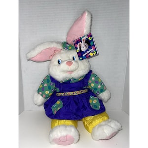 Puede incluir: Una taza de cerámica blanca con un asa negra y el texto "But First, Coffee" en negrita negra. La taza está sobre un fondo borroso. La taza mide aproximadamente 10 cm de altura.