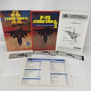 May include: Vintage F-15 Strike Eagle II computer game set. The set includes game boxes, manuals, and floppy disks. The boxes feature images of an F-15 fighter jet. The keyboard controls are also visible.