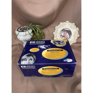 May include: A blue box for an HP PhotoSmart C200 digital camera. The box features the HP Hewlett Packard logo and the words "Expanding Possibilities." The box has a picture of the camera and a woman's face.