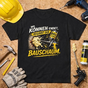 Puede incluir: Camiseta negra con un gráfico que presenta una pistola de espuma de construcción y el texto alemán "Wo Können Endet, Beginnt Der Bauschaum." El diseño incluye una combinación de colores amarillo y negro, con un efecto de pared desgastada.