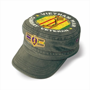 May include: Olive green military-style cap with a flat brim. The cap features a circular design with the words "Vietnam War Veteran" and a map of Vietnam. A "Purple Heart" and "Combat Veteran" patch are on the side.
