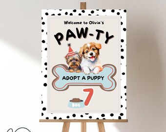 May include: A welcome sign for a 7th birthday party with a paw print theme. The sign features a black and white polka dot background with a brown bone shape. The bone has a blue center with the text "Adopt a Puppy" and a red number 7. Two cartoon puppies are on the bone, one with a party hat. The text "Welcome to Olivia's Paw-Ty" is at the top of the sign.