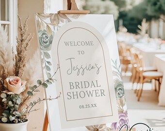 May include: A white welcome sign with a floral border and a gold arch. The sign reads "Welcome to Jessica's Bridal Shower 08.25.XX".