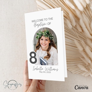 May include: White card with a photo of a girl wearing a white dress and a flower crown. The card says "Welcome to the Baptism of" and "Isabella Williams May 5th, 2025".