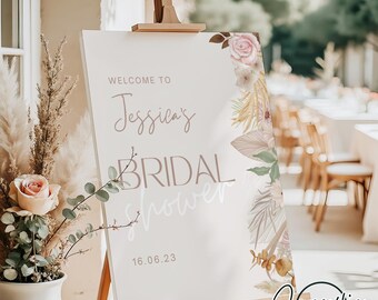 May include: A white sign with a floral design and the text "Welcome to Jessica's Bridal Shower 16.06.23" on an easel.