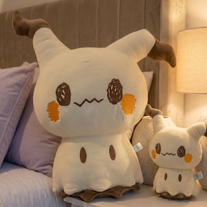 May include: Two Mimikyu Pokémon plush toys, one large and one small. The toys are cream-colored with brown and orange details. The larger toy is approximately 46 cm tall.