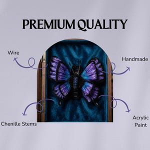 May include: A handmade butterfly sculpture with purple and blue wings, displayed in a wooden frame against a teal velvet backdrop. The text "PREMIUM QUALITY" is at the top. The butterfly is made with wire, chenille stems, and acrylic paint.