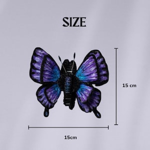 May include: A decorative butterfly with a wingspan of 15 cm (5.9 inches). The butterfly features a gradient of purple and blue hues on its wings, with a black body. The word "SIZE" is at the top of the image.