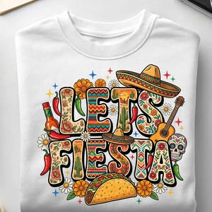May include: White crewneck sweatshirt with a colorful "Let's Fiesta" graphic. The design includes sombreros, a guitar, a taco, chili peppers, and floral elements. A festive and fun design for a celebration.