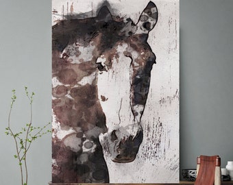 May include: A watercolor painting of a brown and white horse's head with a textured background. The painting is framed and hanging on a wall above a wooden cabinet and a brown leather chair.