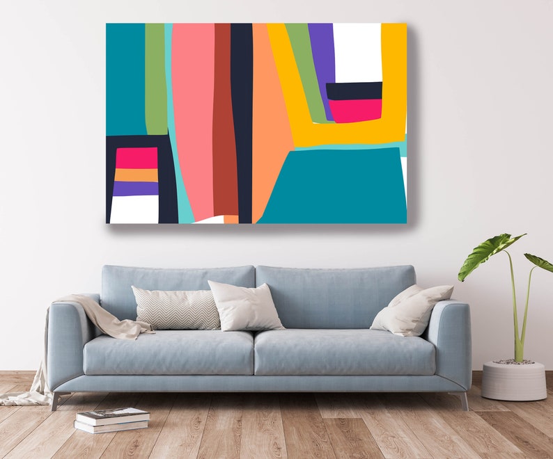May include: Abstract art canvas print featuring a vibrant composition of geometric shapes. The artwork showcases a palette of teal, pink, orange, yellow, and purple against a white background. The canvas is displayed above a light blue sofa, creating a modern interior design.