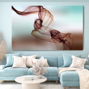 Könnte beinhalten: Abstrakter Kunstdruck mit einem wirbelnden, durchscheinenden braunen Design auf einem hellblauen und braunen Hintergrund. Der Druck hängt an einer hellblauen Wand in einem Wohnzimmer.