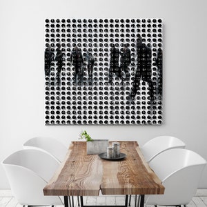 Pode incluir: Uma impressão de arte abstrata em preto e branco com um padrão de círculos e a palavra "0000" repetida em todos os lugares. A impressão está pendurada em uma parede branca acima de uma mesa de madeira com quatro cadeiras brancas.