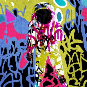 May include: A white astronaut suit with a black helmet is covered in colourful graffiti, including pink, yellow, blue, and green. The background is a black canvas with more graffiti.