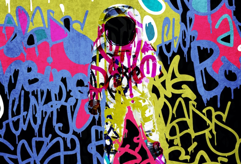 May include: A white astronaut suit with a black helmet is covered in colourful graffiti, including pink, yellow, blue, and green. The background is a black canvas with more graffiti.