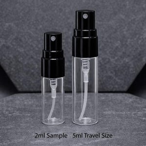May include: Two clear glass spray bottles with black caps. The bottles are labeled as 2ml Sample and 5ml Travel Size. The bottles have a white internal tube and spray mechanism. The background is a dark gray.