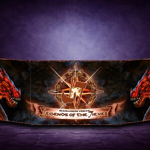 Könnte beinhalten: Ein Fantasy-Spielzubehör mit einem zentralen Emblem mit einer Musiknote und einem Kompass-Design, flankiert von zwei roten Drachenköpfen. Das Banner lautet "Legends of the Thieves" und "Blackwords Verlag".