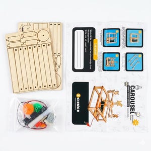May include: A wooden carousel science kit with unassembled wooden parts, a motor, gears, and a manual. The manual includes diagrams and the text "CAROUSEL Children's Science Laboratory Manual". The kit is designed for educational purposes.