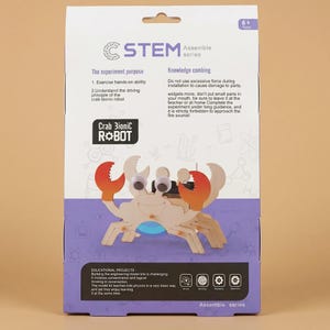 Peut inclure: Un kit STEM Assemble series avec un robot Crab Bionic. Le kit comprend des pi&egrave;ces en bois, des yeux globuleux et des pinces rouges et orange. La bo&icirc;te contient du texte sur le but de l'exp&eacute;rience et les projets &eacute;ducatifs.