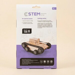Może przedstawiać: Zestaw edukacyjny STEM Assemble z modelem Electric Tank. Pudełko jest biało-fioletowe, z tekstem opisującym cel eksperymentu i instrukcje bezpieczeństwa. Model czołgu wykonany jest z jasnego drewna z czarnymi kołami.
