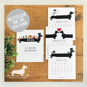 May include: A 2026 12-month calendar featuring dachshund illustrations. The calendar includes monthly designs with seasonal themes and the text "BESTSELLER FOR THE 9TH YEAR!". The calendar is displayed on a wooden background.