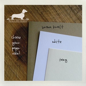May include: A selection of paper colors: brown kraft, white, and ivory. The text "choose your paper color!" is written on the left side of the image. The Pickle Dog Design logo is in the upper left corner.