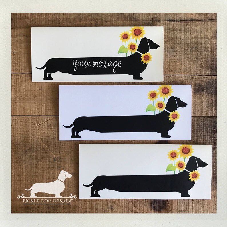 May include: Three white rectangular cards with a black dachshund silhouette wearing a sunflower collar. The top card has the text "your message" in cursive. The cards are on a wooden background.