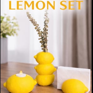May include: A 3D printed lemon set featuring a candle holder, a decorative vase, and a napkin holder. The candle holder has a small LED candle. The vase is made of three stacked lemons. The text "3D PRINTED LEMON SET" is at the top.