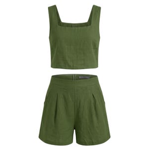 May include: Olive green two-piece outfit. The set includes a square-neck crop top and high-waisted shorts. The shorts have pleats and pockets. The fabric appears to be linen or a similar lightweight material. The outfit is designed for warm weather.