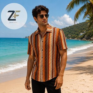 May include: Short-sleeved button-down shirt with a geometric pattern in shades of brown, orange, and white. The shirt has a classic collar and is worn with black pants. The background shows a beach scene with palm trees and blue water.