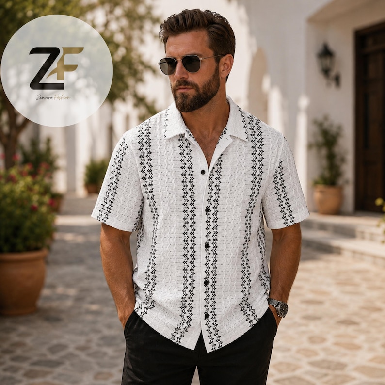 May include: White short-sleeve shirt with a textured pattern and black vertical stripes. The shirt has a classic collar and button-down front. The shirt is paired with black pants. The ZF logo is in the upper left corner.