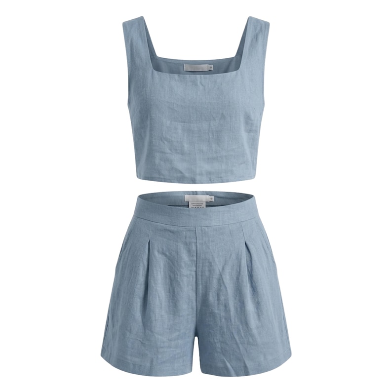 May include: A light blue linen two-piece set. The set includes a square-neck crop top and high-waisted shorts with pleats. The fabric has a slightly textured appearance. The outfit is designed for a casual, warm-weather look.