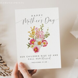 May include: A Mother's Day greeting card with a floral bouquet illustration. The card features the text "Happy Mother's Day" in elegant script, and a quote from Proverbs 31:28. The bouquet includes pink, yellow, and white flowers with green foliage.