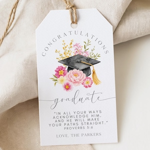 May include: White graduation gift tag with a watercolor illustration of a black graduation cap, pink and yellow flowers, and the word "graduate". The tag includes the text "Congratulations" and a Bible verse.