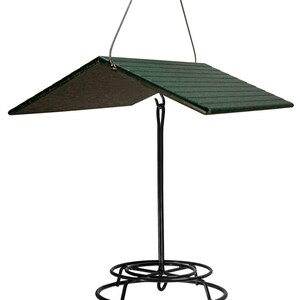 May include: A black metal bird feeder with a green plastic roof. The feeder has a round base and a hanging loop.