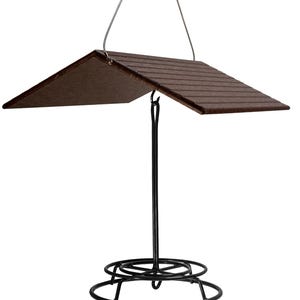 May include: A black metal bird feeder with a brown wooden roof. The feeder has a hanging loop and a circular base.