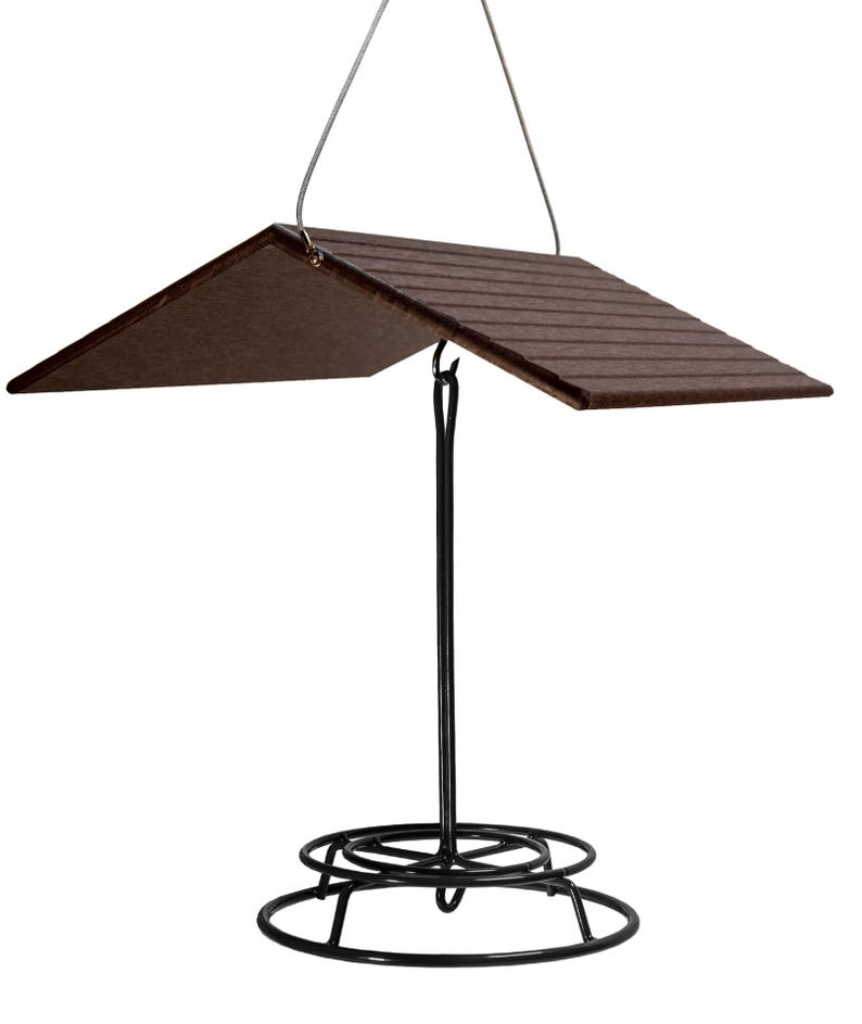 May include: A black metal bird feeder with a brown wooden roof. The feeder has a hanging loop and a circular base.