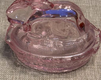 Lapin rose en verre sur un nid de poule
