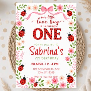 May include: A birthday invitation card featuring a watercolor border of green vines, pink flowers, and red ladybugs. The text reads: our little love bug is turning ONE, YOU'RE INVITED TO Sabrina's 1ST BIRTHDAY, 20 APRIL | 2 - 4 PM, 123 Anywhere St.