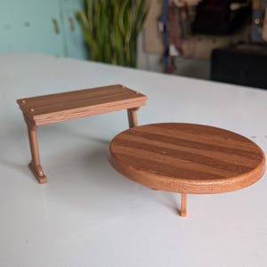 May include: A miniature brown plastic rectangular bench with a wood grain texture and a matching miniature brown plastic round table with a wood grain texture. Both items feature simple structural legs and a smooth, molded finish throughout.
