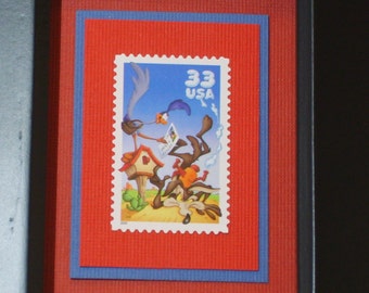 May include: A red, white, and blue postage stamp featuring a cartoon roadrunner and coyote. The stamp reads "33 USA".