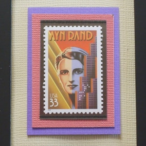 Pode incluir: Um selo postal de estilo vintage com um retrato de Ayn Rand, uma romancista e filósofa americana. O selo é emoldurado com uma borda roxa, rosa e branca.
