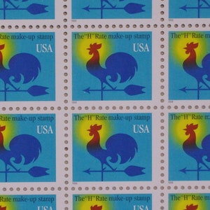 May include: A sheet of nine postage stamps featuring a blue rooster weather vane with a yellow halo and the text "The "H" Rate make-up stamp" and "USA".